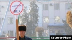 Житель Тараза Акыл Бейсембаев стоит возле здания регионального офиса президентской партии "Нур Отан" со знаком, на котором написано «Референдум 2011 НЕТ». Тараз, 12 января 2011 года. Фото предоставлено жамбылским филиалом партии "Алга".