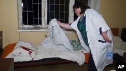 A nurse cleans the bed linen of a patient who was injured after a Russian attack on a psychiatric hospital in Kharkiv on April 27.