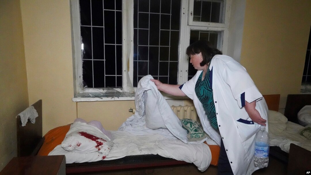 O asistentă curăță lenjeria de pat a unui pacient care a fost rănit după un atac rusesc asupra unui spital de psihiatrie din Harkov, pe 27 aprilie.
