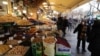 Iranians walk past shops selling dried fruits and nuts at the Grand Bazaar in the capital Tehran on January 20 in the wake of a bloody crackdown on unprecedented nationwide protests.