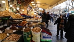 Iranians walk past shops selling dried fruits and nuts at the Grand Bazaar in the capital Tehran on January 20 in the wake of a bloody crackdown on unprecedented nationwide protests.