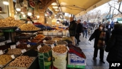Iranians walk past shops selling dried fruits and nuts at the Grand Bazaar in the capital Tehran on January 20 in the wake of a bloody crackdown on unprecedented nationwide protests.