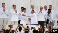 Colombian President Juan Manuel Santos (left) and the head of the FARC guerrilla group, Timoleon Jimenez aka Timochenko, shake hands during the signing of the historic peace agreement between the Colombian government and FARC on September 26.