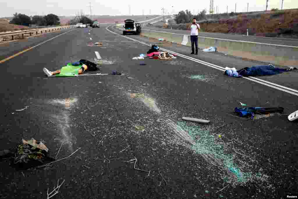 Cadavrele civililor israelieni uciși sunt împrăștiate pe un drum din zona Sderot din sudul Israelului. Fotografie făcută imediat după atac.