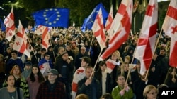 Protesters wave flags during a pro-Europe rally in Tbilisi on October 20, ahead of the parliamentary elections.