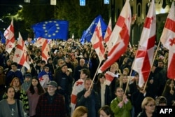 Protesters in Tbilisi wave flags during a pro-Europe rally ahead of the 2024 parliamentary elections.