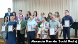 Alekszander Mamkin, a „kísérletező" tanár (szemüvegben, a kamerába nézve mosolyog) az „Év tanára" gálán.