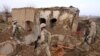 FILE: U.S. Marines walk through the rubble of a house destroyed in an airstrike in Helmand.