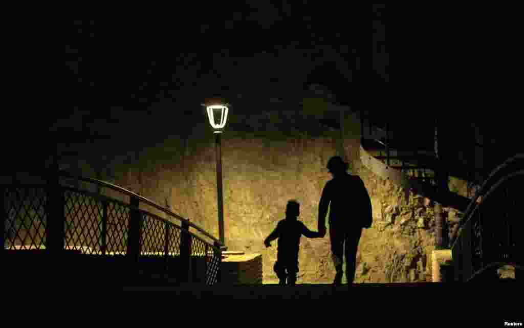 A woman and child cross a footbridge in the historical part of Tbilisi on October 15. (REUTERS/David Mdzinarishvili)