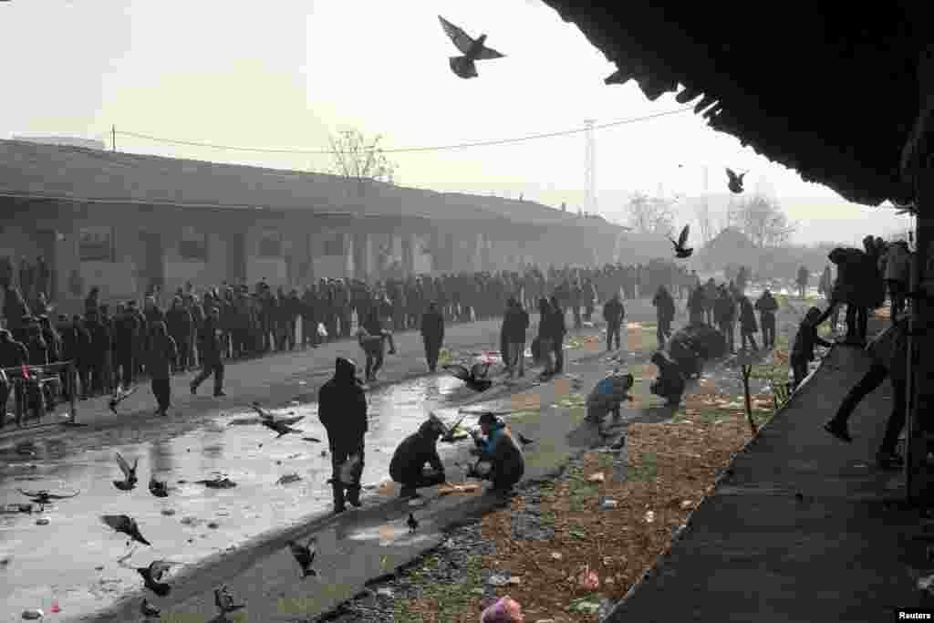 Migrants stand in line to receive free food outside a derelict customs warehouse in Belgrade, Serbia. (Reuters/Marko Djurica) 