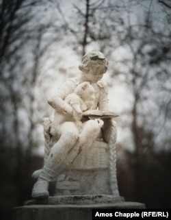 A Soviet-era statue of a girl reading to a toy bear in the center of New York