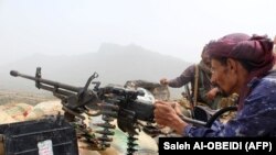 Yemen -- A Yemeni pro-government fighter fires a heavy machine gun as Emirati supported forces take over Huthi bases on the frontline of Kirsh between the province of Taez and Lahj, southwestern Yemen, on July 1, 2018. The United Arab Emirates on Sunday a