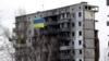 A Ukrainian national flag flies in front of a destroyed residential building in Borodyanka on February 18.