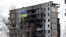 A Ukrainian national flag flies in front of a destroyed residential building in Borodyanka on February 18.
