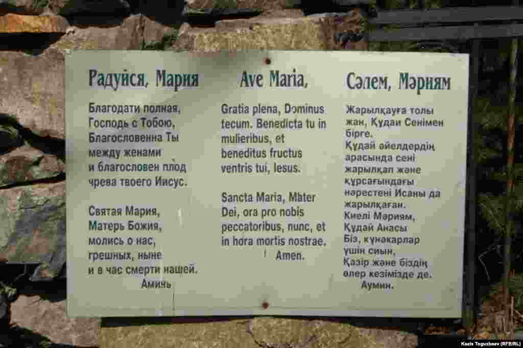 Текст религиозной песни "Радуйся, Мария!" на трех языках возле статуи Девы Марии. Алматы, 30 марта 2013 года.