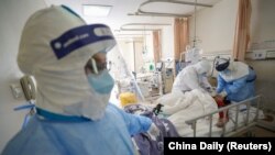 Medical workers in protective suits attend to a patient inside an isolated ward at a hospital in the Chinese city of Wuhan, which is the epicenter of the coronavirus outbreak. 