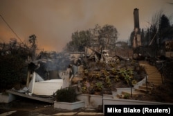 O casă arsă se află în ruină, în timp ce vânturile puternice care alimentează incendiile devastatoare din zona Los Angeles forțează oamenii să se evacueze, 8 ianuarie 2025.