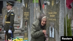 Në një varrezë në Lviv, në Ukrainën perëndimore, një grua viziton varrin e një të afërmi të vrarë duke luftuar kundër pushtimit rus, më 23 maj 2025.