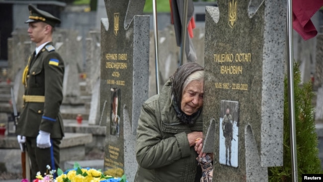 Në një varrezë në Lviv, në Ukrainën perëndimore, një grua viziton varrin e një të afërmi të vrarë duke luftuar kundër pushtimit rus, më 23 maj 2025.