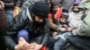 Asylum seekers from Afghanistan rub a fellow protester's feet against the cold as they gather to protest at the 'Grand Place' in Mons, Belgium. (file photo) 