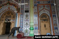 Чоловік розгортає килим для молитви в мечеті перед Рамаданом, Равалпінді, Пакистан, 5 квітня 2021 року