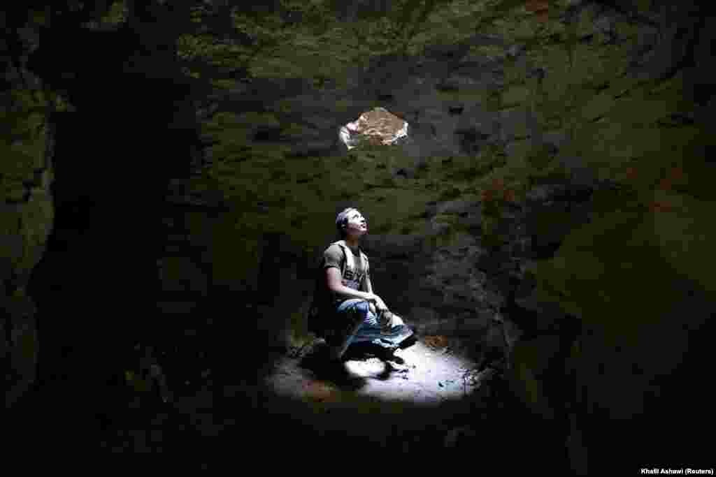 A man looks out of an opening of a makeshift shelter in an underground cave in Idlib, Syria. (Reuters/Khalil Ashawi)