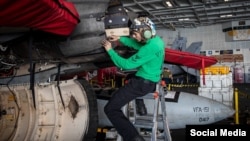 یک خدمه ناو هواپیمابر آبراهام لینکلن، مشغول عملیات تعمیر و نگهداری دوره‌ای یک جنگنده