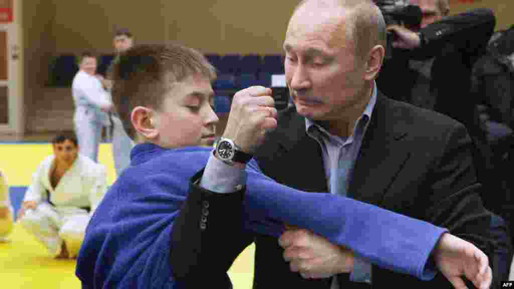 Russian Prime Minister Vladimir Putin shows a hold to a young judo practitioner in the Siberian city of Kemerovo. (AFP)