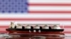 Një model i një anijeje-cisternë për transportin e LNG-së shihet përpara flamurit amerikan në këtë ilustrim, të realizuar më 19 maj 2022.