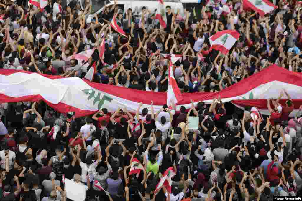 Anti-government protesters shout slogans in Beirut on October 20. Tens of thousands of Lebanese protesters of all ages gathered in major cities and towns nationwide, with each hour bringing hundreds more people to the streets. (AP/Hassan Ammar)