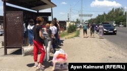 Базар маңындағы аялдамада автобус күтіп тұрған адамдар. Алматы, 3 маусым 2020 жыл.