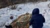 Nadia Volkova leans over the body of her mother, Katya, who was killed during shelling in the eastern Ukrainian city of Avdiyivka on February 1. (RFE/RL/Christopher Miller)