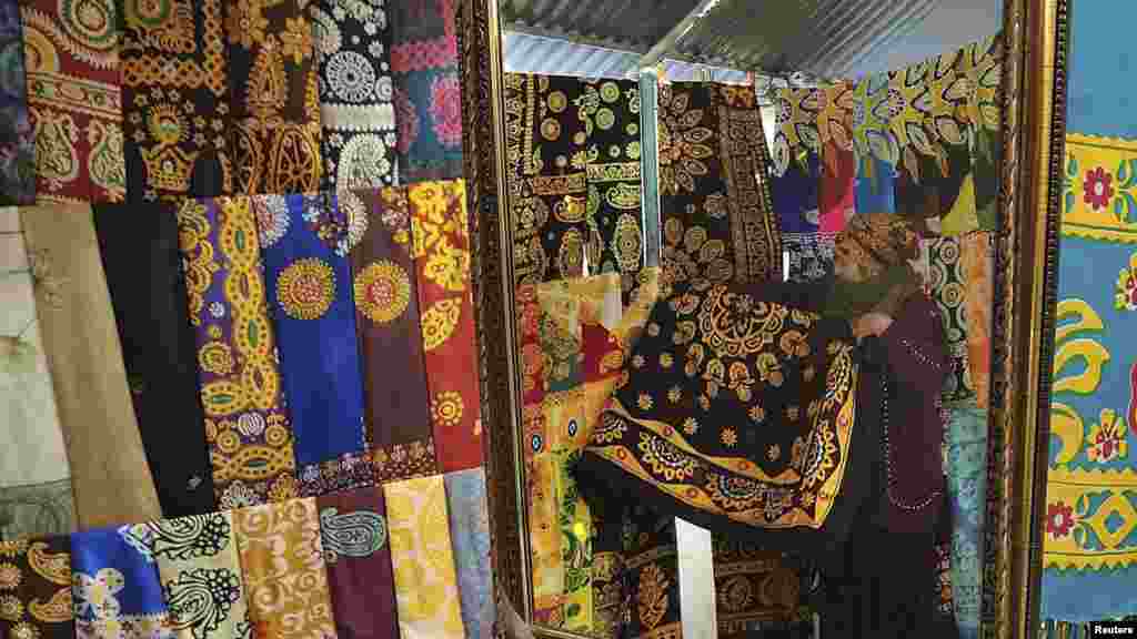 A woman is reflected in a mirror at a market in the Turkmen capital, Ashgabat, on February 8. (REUTERS/Aman Mehinli)