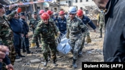 Rescuers carry away the body of a victim at a blast site hit by a rocket in the Azerbaijani city of Ganca on October 11.