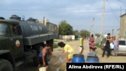 Местные жители запасаются привозной питьевой водой. Поселок Кенкияк Актюбинской области, 11 июля 2011 года.