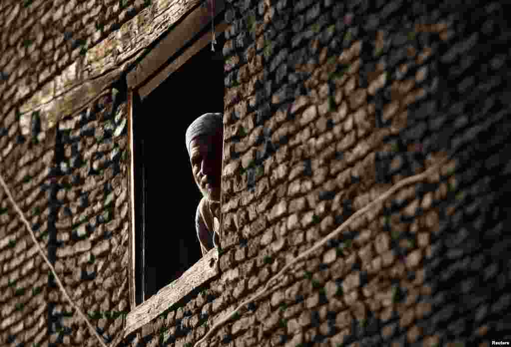 Кашмірац выглядае з акна свайго дома ў цэнтры Шрынагару.