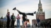 TOPSHOT - A Russian gymnast poses for a photo at the Red Square in front of the Kremlin's Spasskaya tower (R) and St. Basil's cathedral in downtown Moscow, on September 23, 2024.