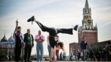 TOPSHOT - A Russian gymnast poses for a photo at the Red Square in front of the Kremlin's Spasskaya tower (R) and St. Basil's cathedral in downtown Moscow, on September 23, 2024.