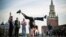 TOPSHOT - A Russian gymnast poses for a photo at the Red Square in front of the Kremlin's Spasskaya tower (R) and St. Basil's cathedral in downtown Moscow, on September 23, 2024.