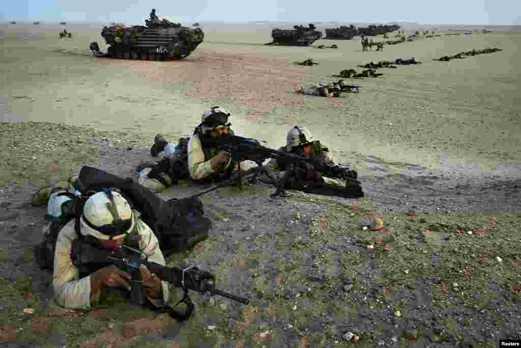 U.S. Marines in combat gear take their positions during a last-minute exercise in northern Kuwait near the border with Iraq on March 18, 2003.