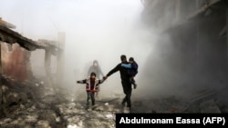 Syrian civilians flee from reported regime air strikes in the besieged Eastern Ghouta region on the outskirts of the capital, Damascus, on February 8. 