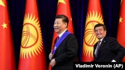 Chinese President Xi Jinping (left) and Kyrgyz President Sooronbai Jeenbekov leave after a joint news conference on the sidelines of the Shanghai Cooperation Organization summit in Bishkek in June 2019.