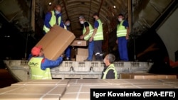 Сотрудники аэропорта «Манас» разгружают груз с гуманитарной помощью, доставленный МЧС России для оказания помощи в борьбе с COVID-19. Июль 2020 года. 