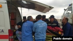 Фавқулодда хизматлар ходимлари портлаш саҳнасида жароҳатланганлардан бирини тез ёрдам машинасига ортмоқда. 6 декабрь, 2025 