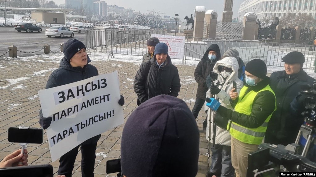 Активист Жанболат Мамай (с плакатом) проводит одиночный пикет. Алматы, 15 января 2021 года.
