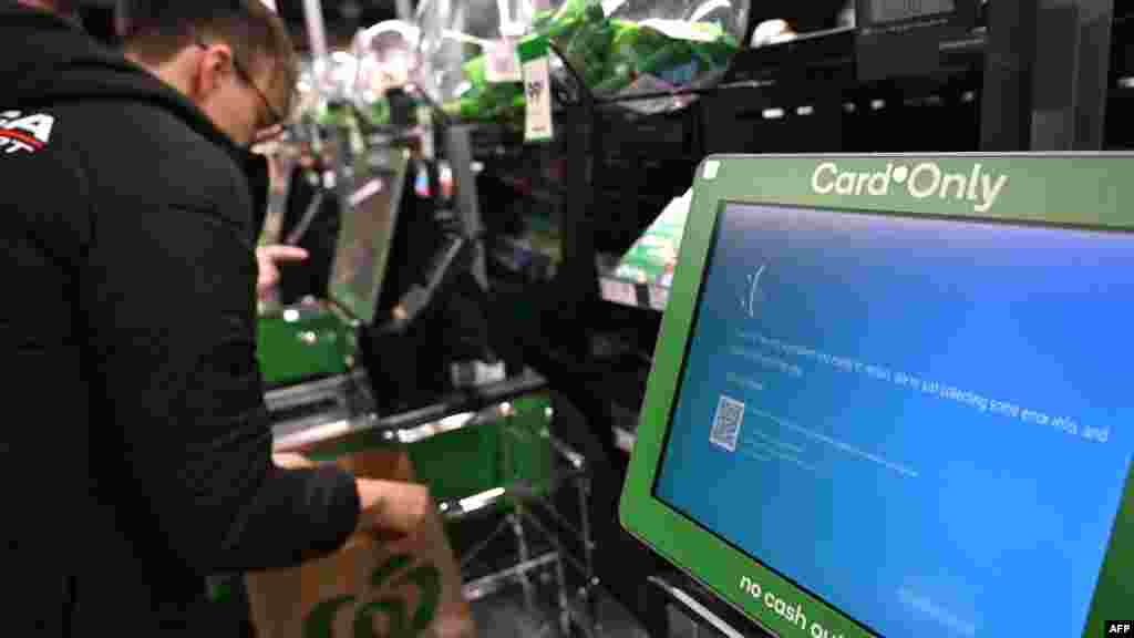 Sydney, Australia &ndash; un client își face cumpărăturile lângă un ecran albastru la terminalele automate ale unui supermarket - 19 iulie 2024.