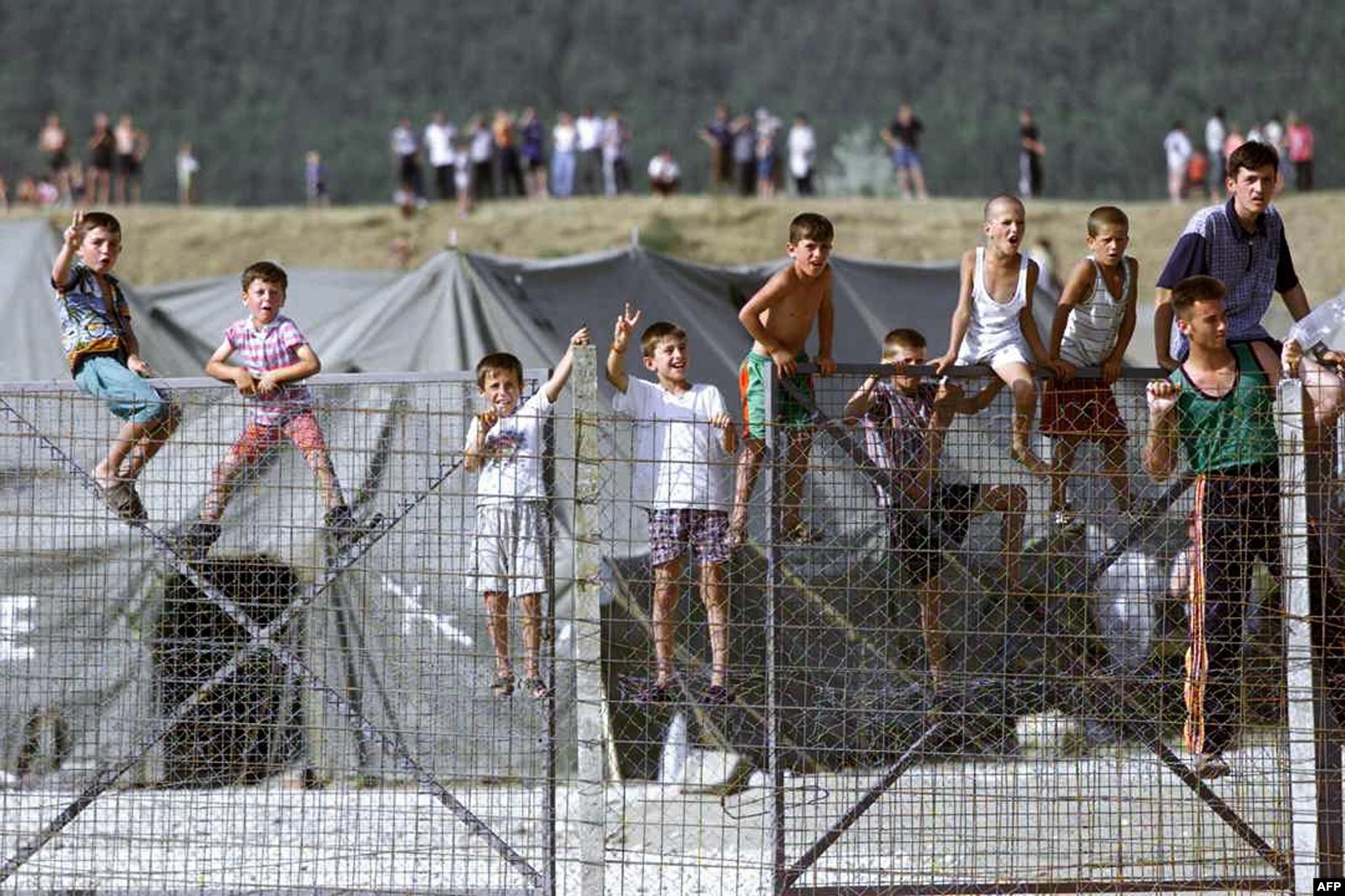Fëmijë shqiptarë në kampin e refugjatëve në Maqedoninë e sotme të Veriut duke shikuar trupat e KFOR-it, që po grumbulloheshin në kufi me Kosovën.