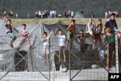 Fëmijë shqiptarë në kampin e refugjatëve në Maqedoninë e sotme të Veriut duke shikuar trupat e KFOR-it, që po grumbulloheshin në kufi me Kosovën.
