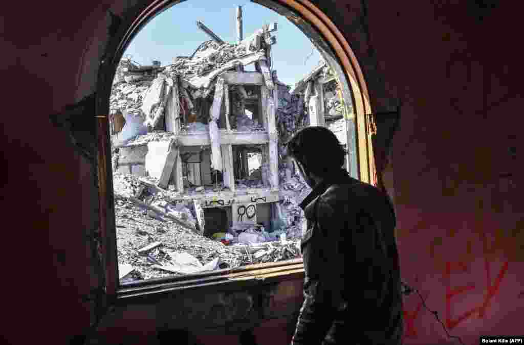 A member of the Syrian Democratic Forces (SDF), backed by U.S. Special Forces, looks out from a building at the front line in Raqqa on October 16. (AFP/Bulent Kilic)