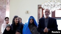 Afghan President Ashraf Ghani (R) speaks to the media after Sharbat Gula (2nd R), the green-eyed "Afghan Girl" whose 1985 photo in National Geographic became a symbol of her country's wars. She arrived in Kabul on November 9.